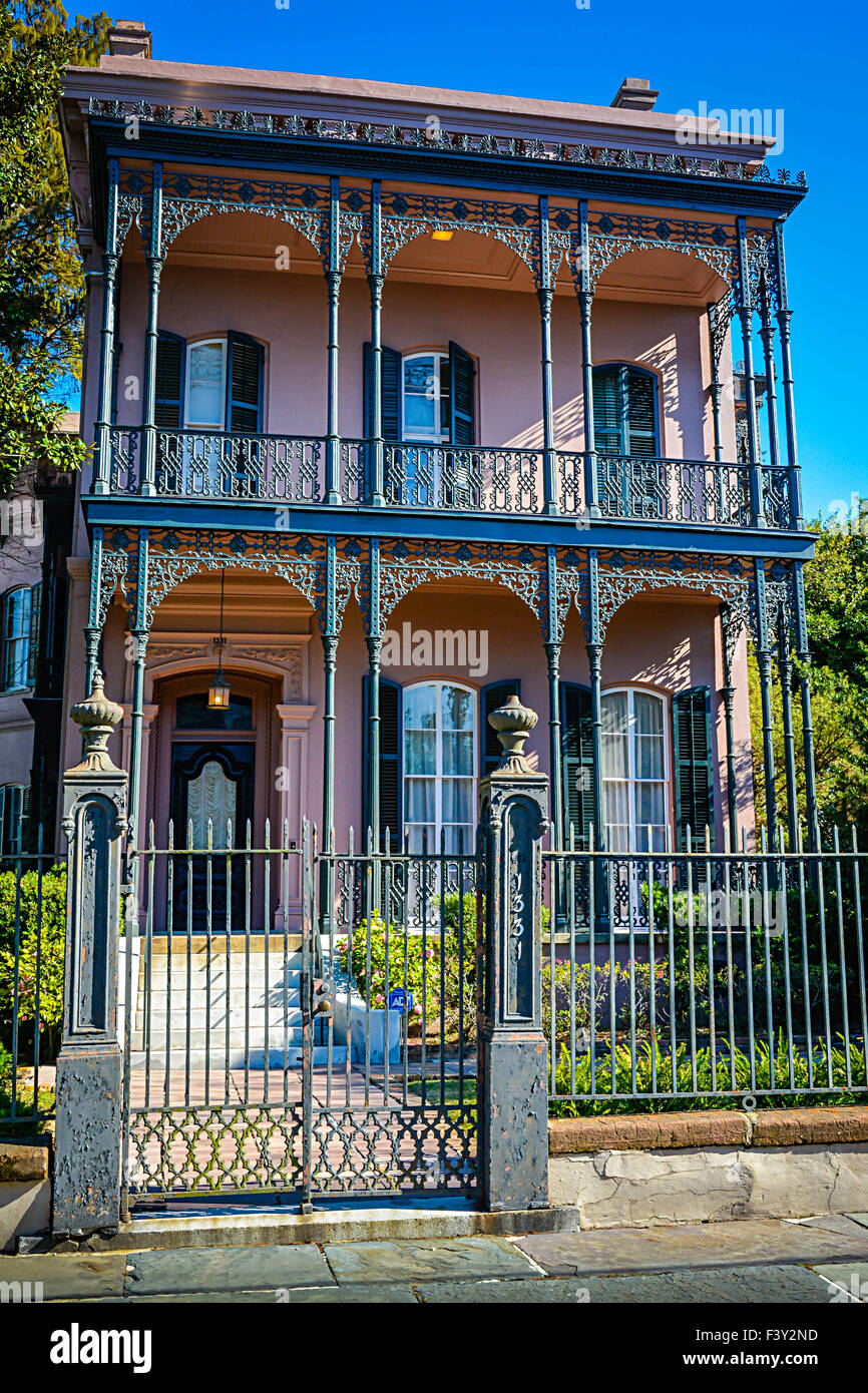 Das wunderschön einzigartige rosa italienisch anmutende Joseph Carroll Haus mit kunstvollen Eisenzäunen im Garden District in New Orleans, LA, USA Stockfoto