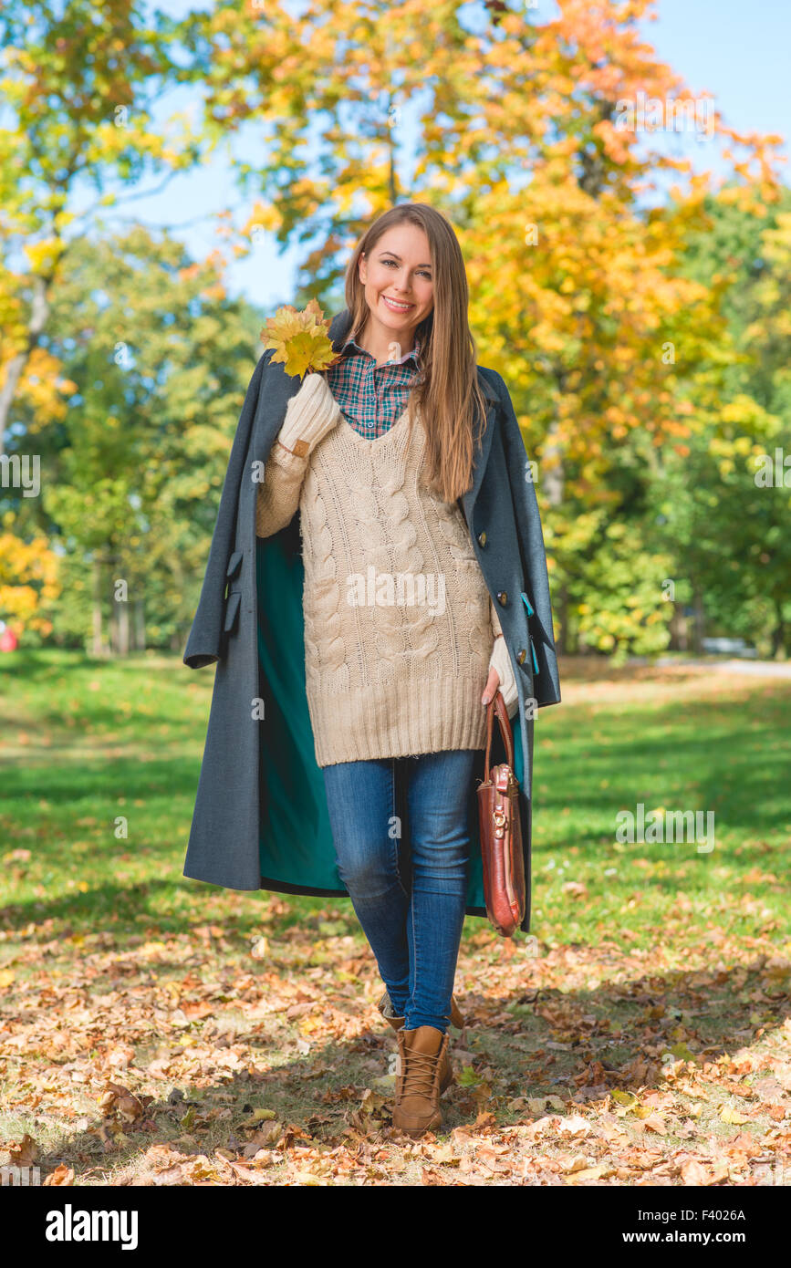 Lächelnde Frau auf Natur Hintergrund im Herbst Stockfoto