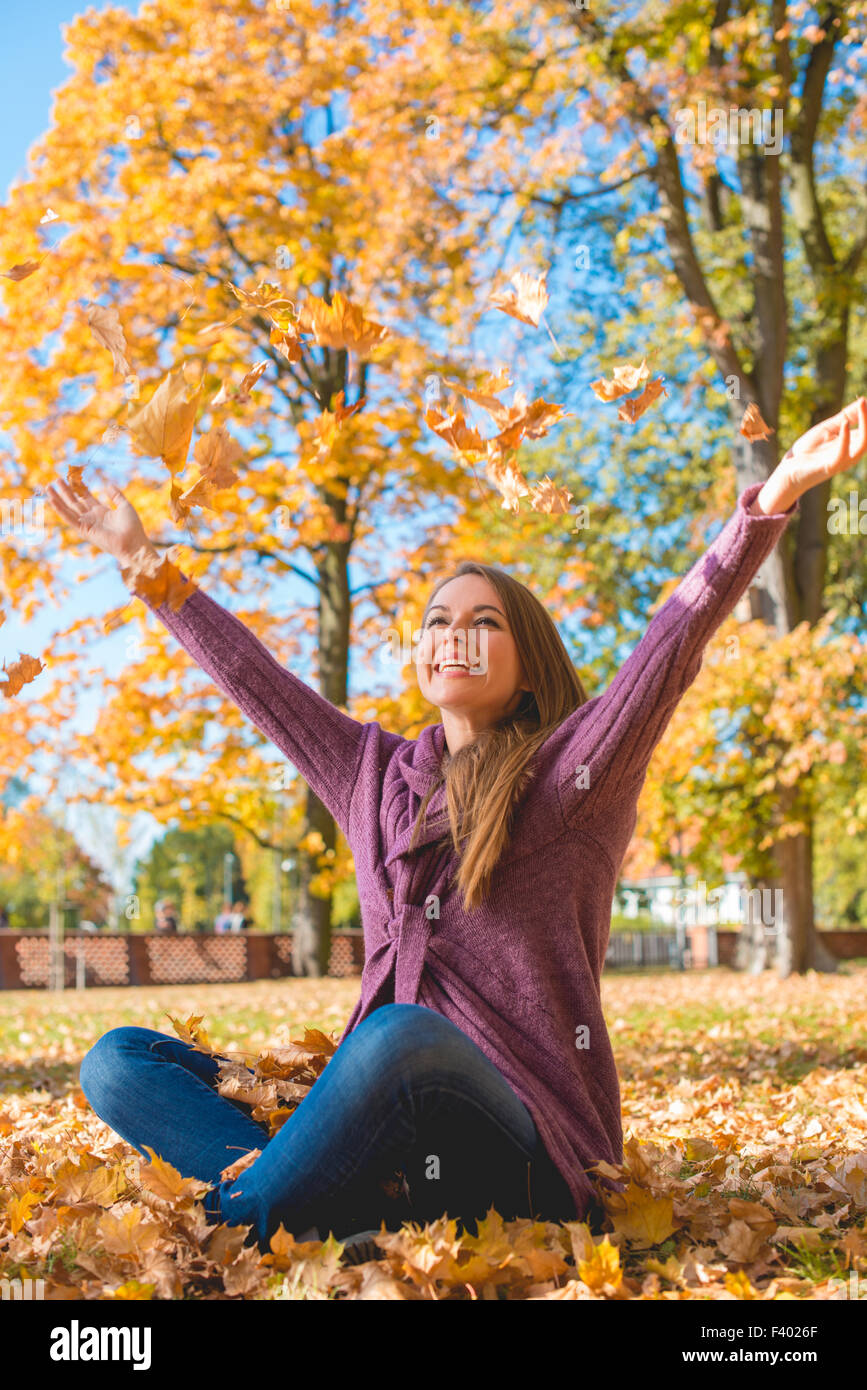 Glückliche junge Frau an einem herbstlichen Park erfreuen Stockfoto