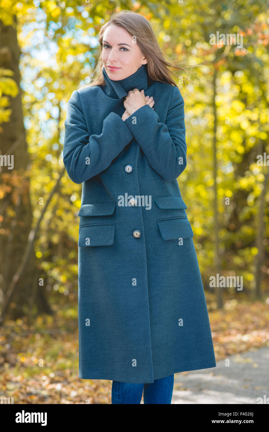 Hübsche Frau im grauen Mantel auf Natur Hintergrund Stockfoto