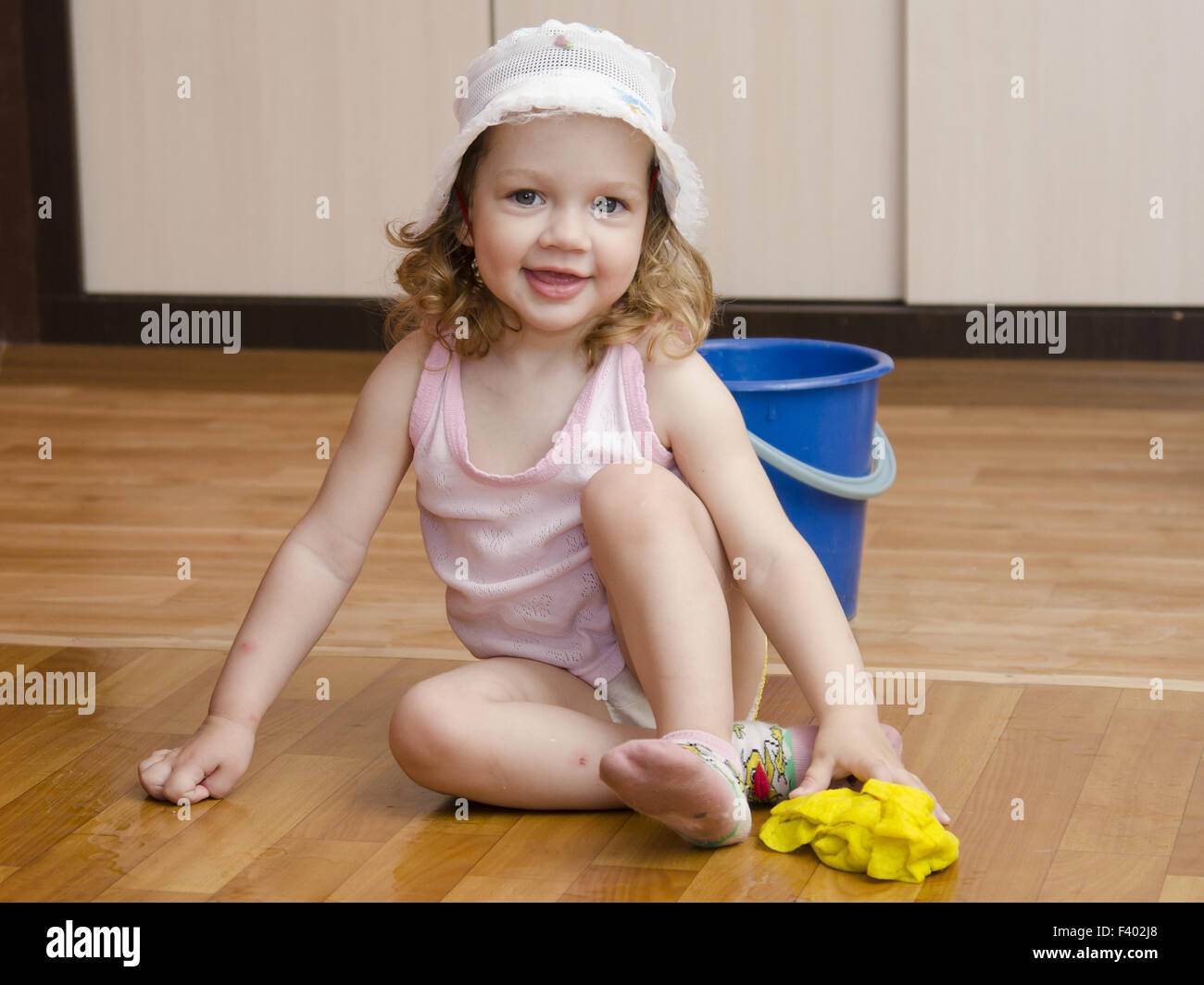 Kleine Mädchen waschen Lappen Böden Stockfoto
