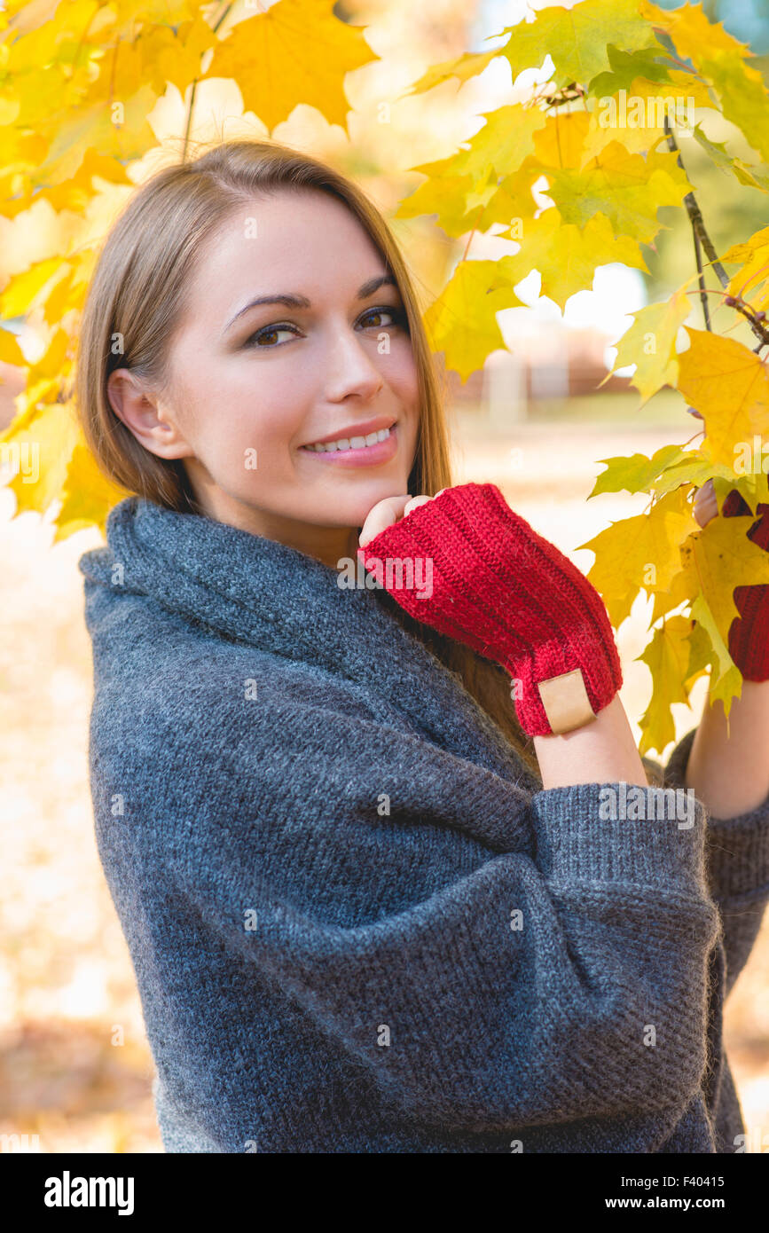 Lächelnde Frau Herbst sammeln Blätter Stockfoto