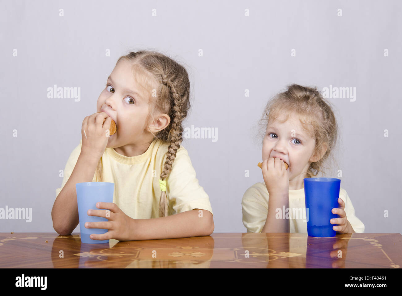 Zwei Kinder einen Muffin zu Essen am Tisch Stockfoto