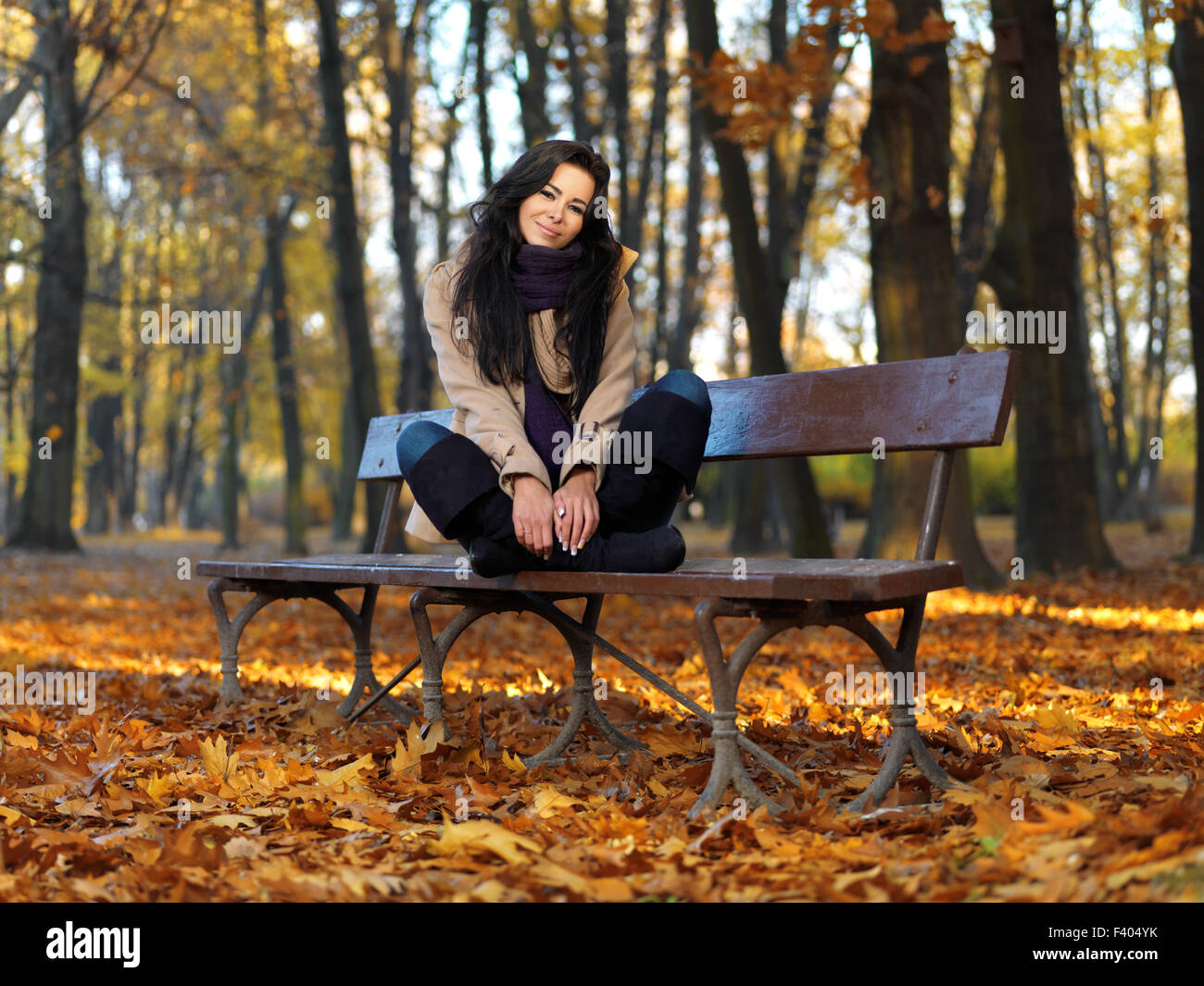 Frau im Herbst Mode auf Bank sitzend Stockfoto