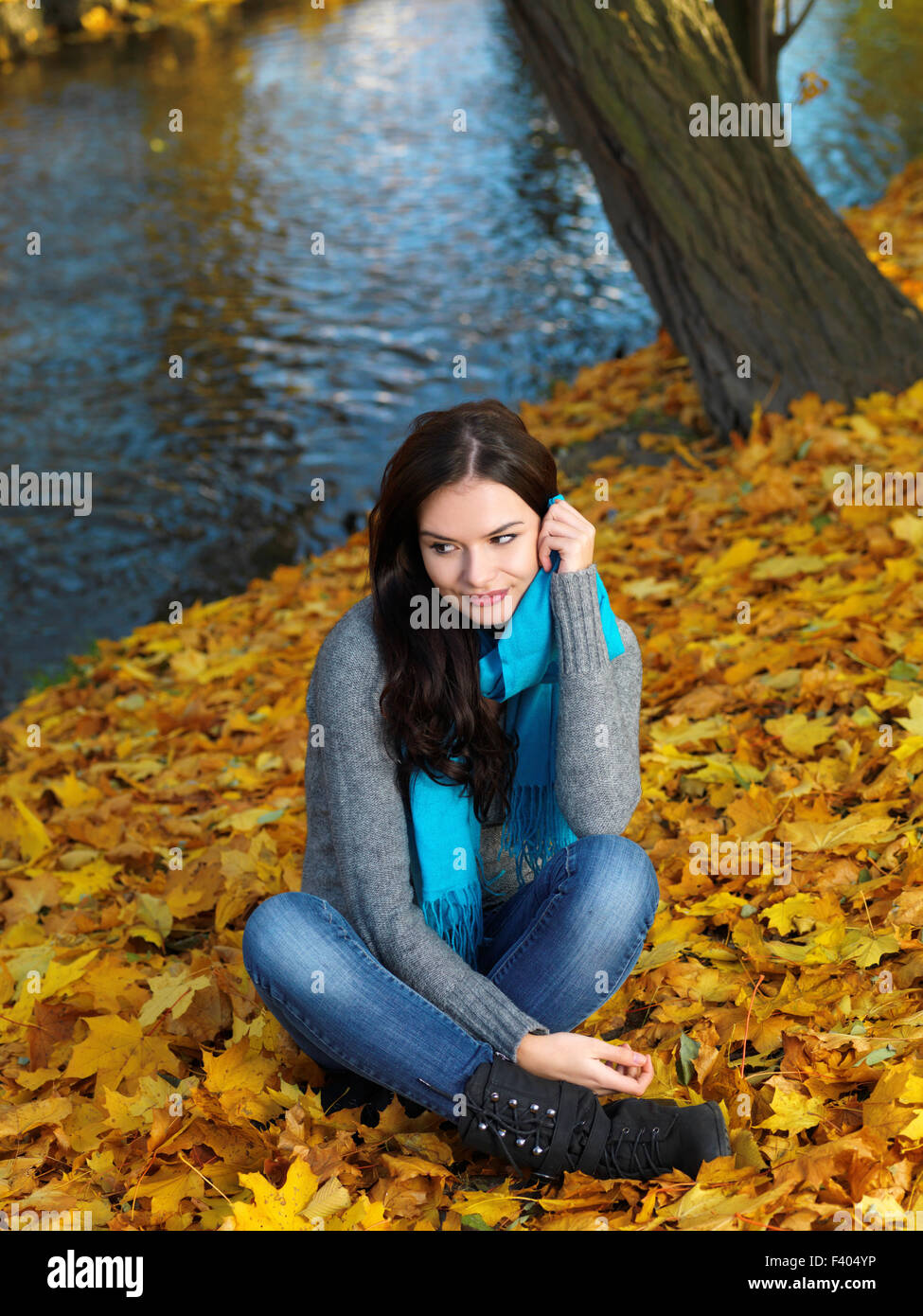Frau im Herbst-Outfit auf trockenen sitzen lässt Stockfoto