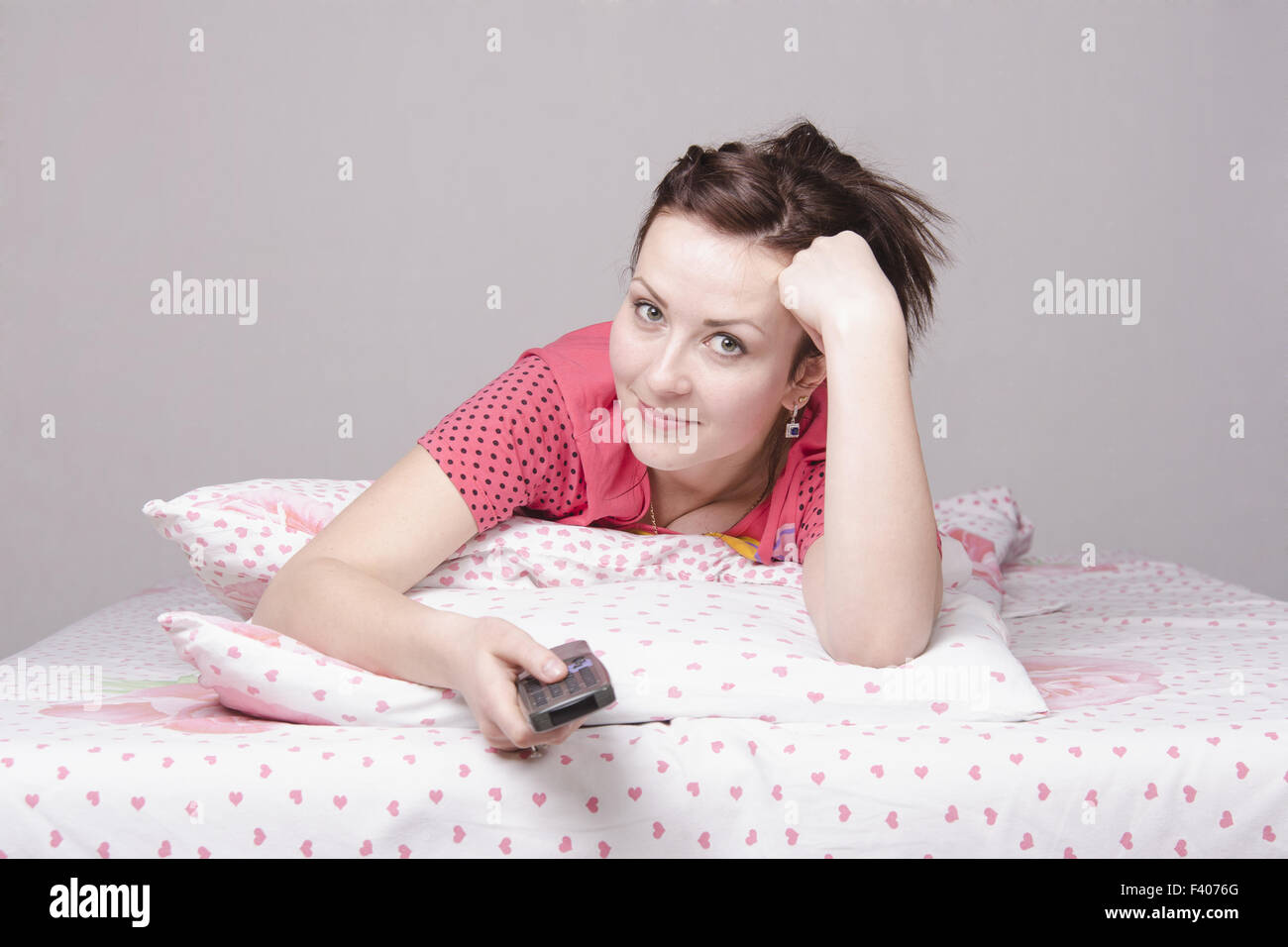 Mädchen im Bett liegen und Fernsehen Stockfoto