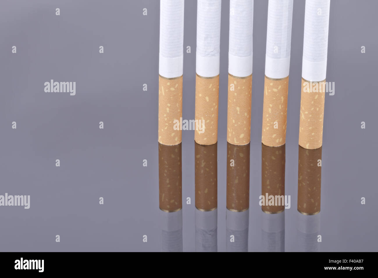 Zigarette auf einer reflektierenden Oberfläche Stockfoto