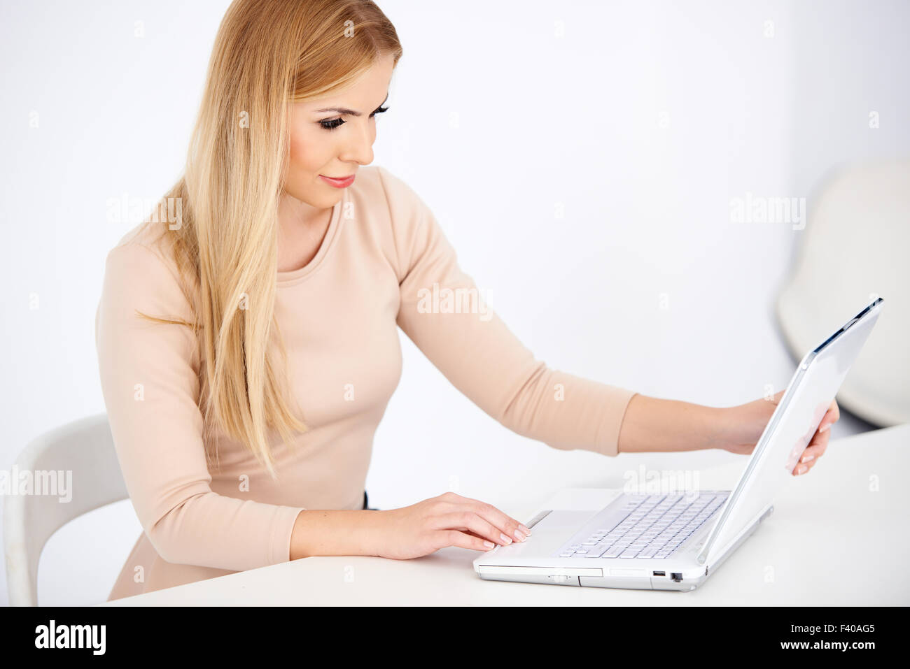 Attraktive blonde Frau auf einem Laptop arbeiten Stockfoto