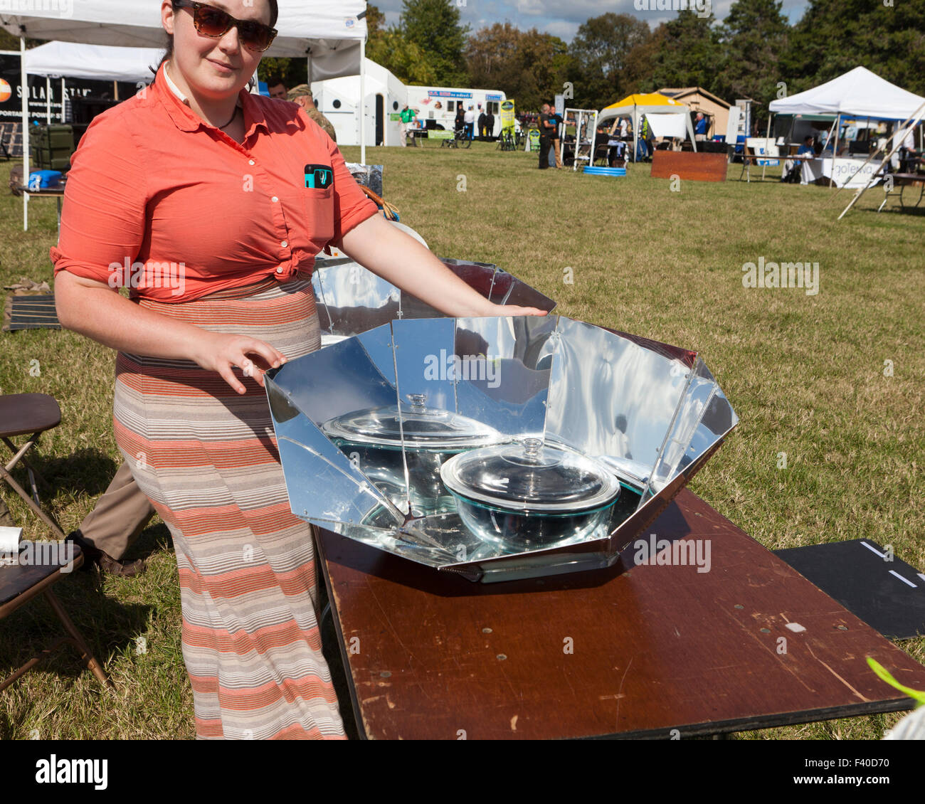 Frau zeigt ein Panel Solarkocher - USA Stockfoto