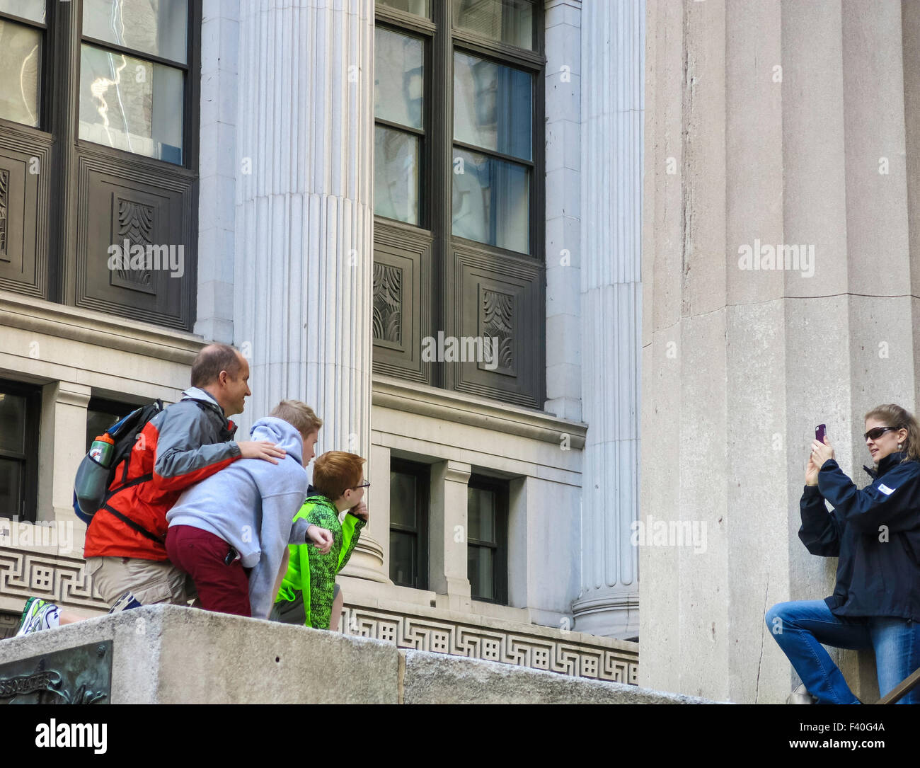 Touristen Familie posiert für Fotos, Federal Hall, Wall Street, NYC, USA Stockfoto