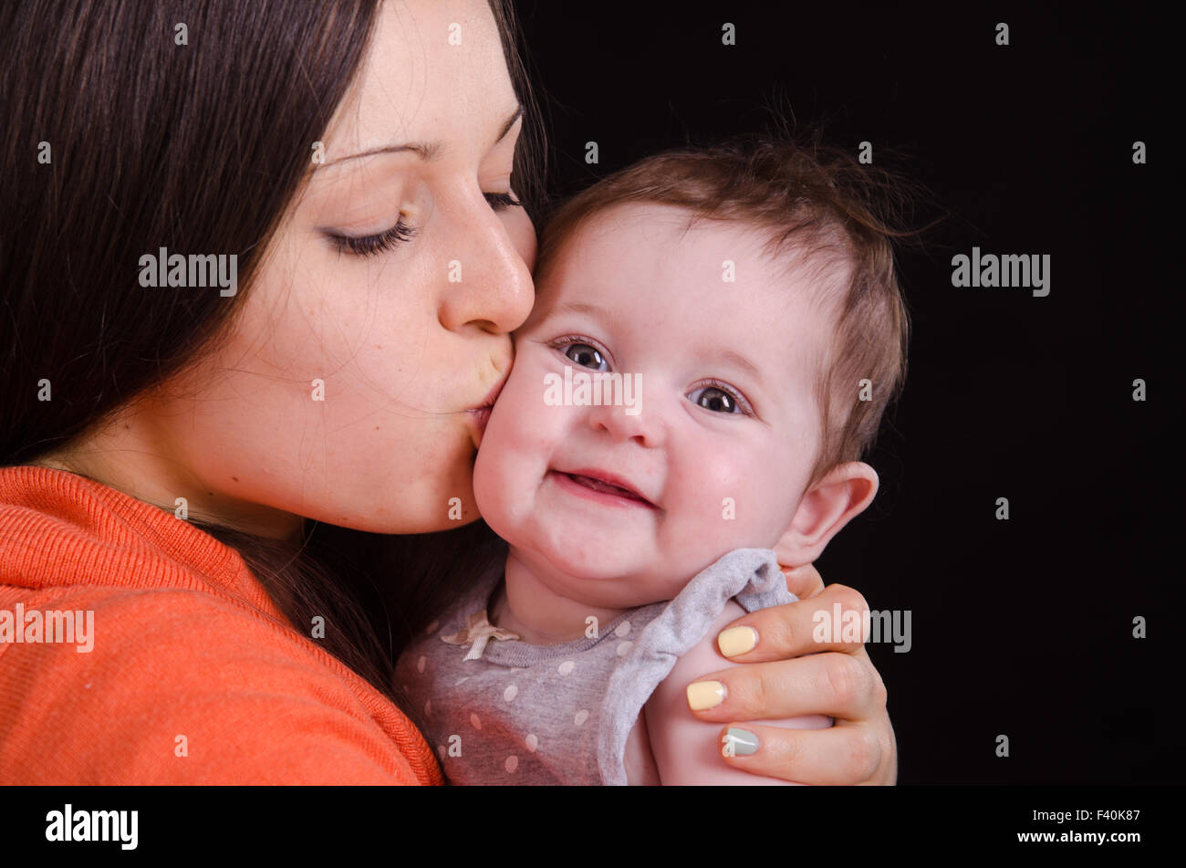 Mutter küsst das Baby von sechs Monaten Stockfoto