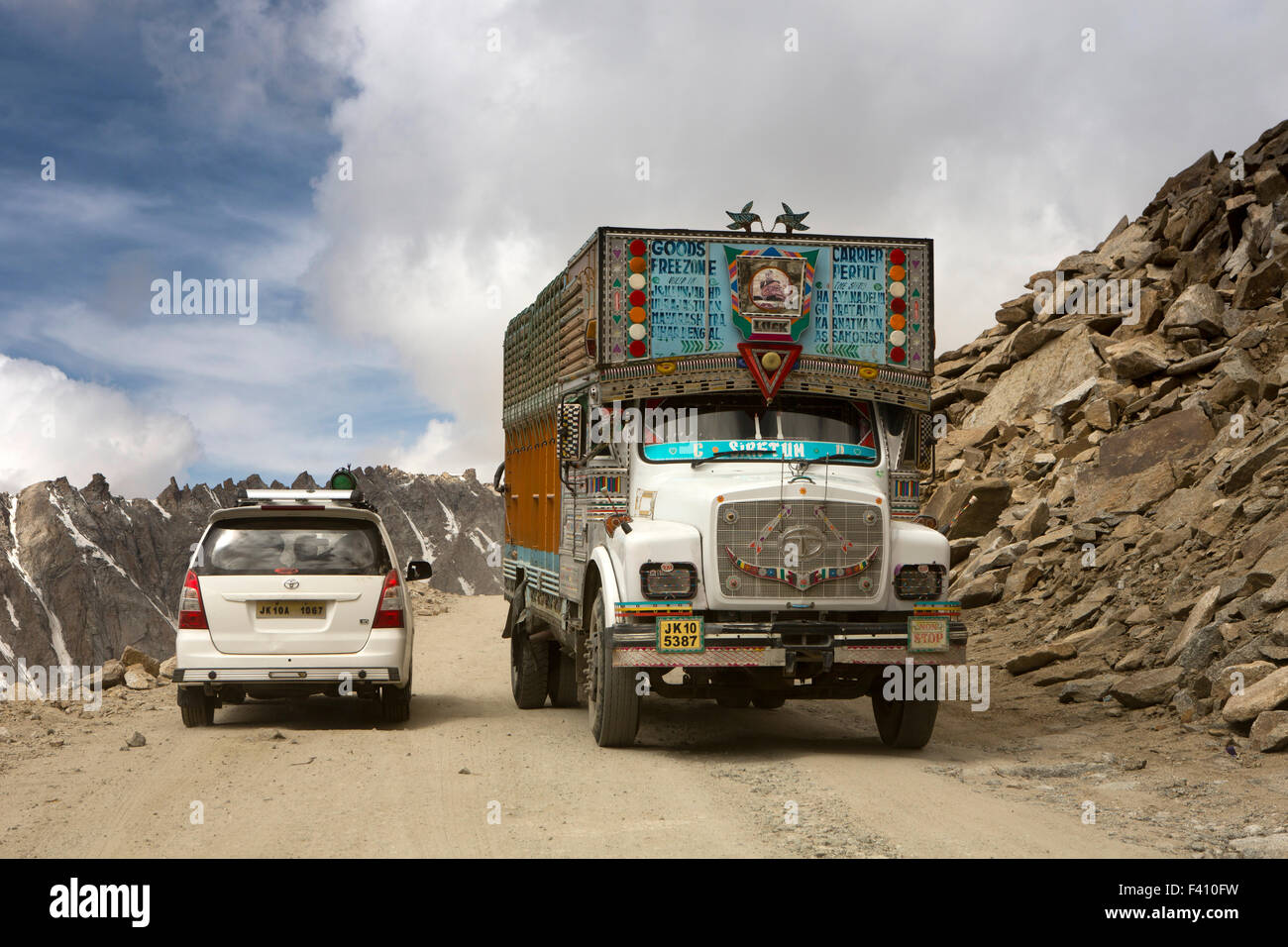 Indien, Jammu & Kashmir, Ladakh, Leh, Weg zum Khardung La pass, Tata LKW und Toyota Innova Auto vorbei an einem großen Punkt Stockfoto