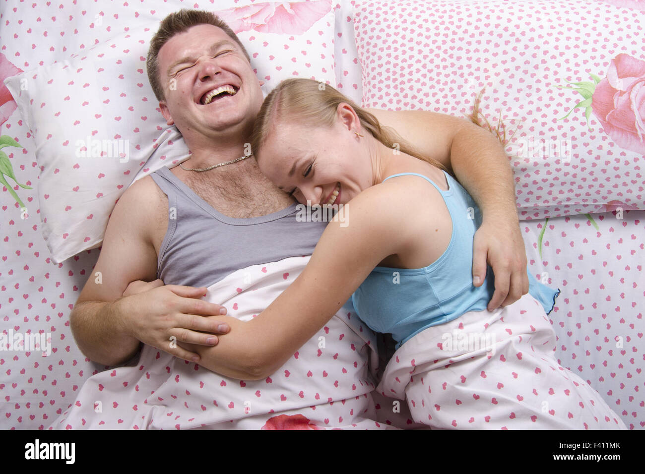 Junges Paar liegt im Bett und lacht Stockfoto