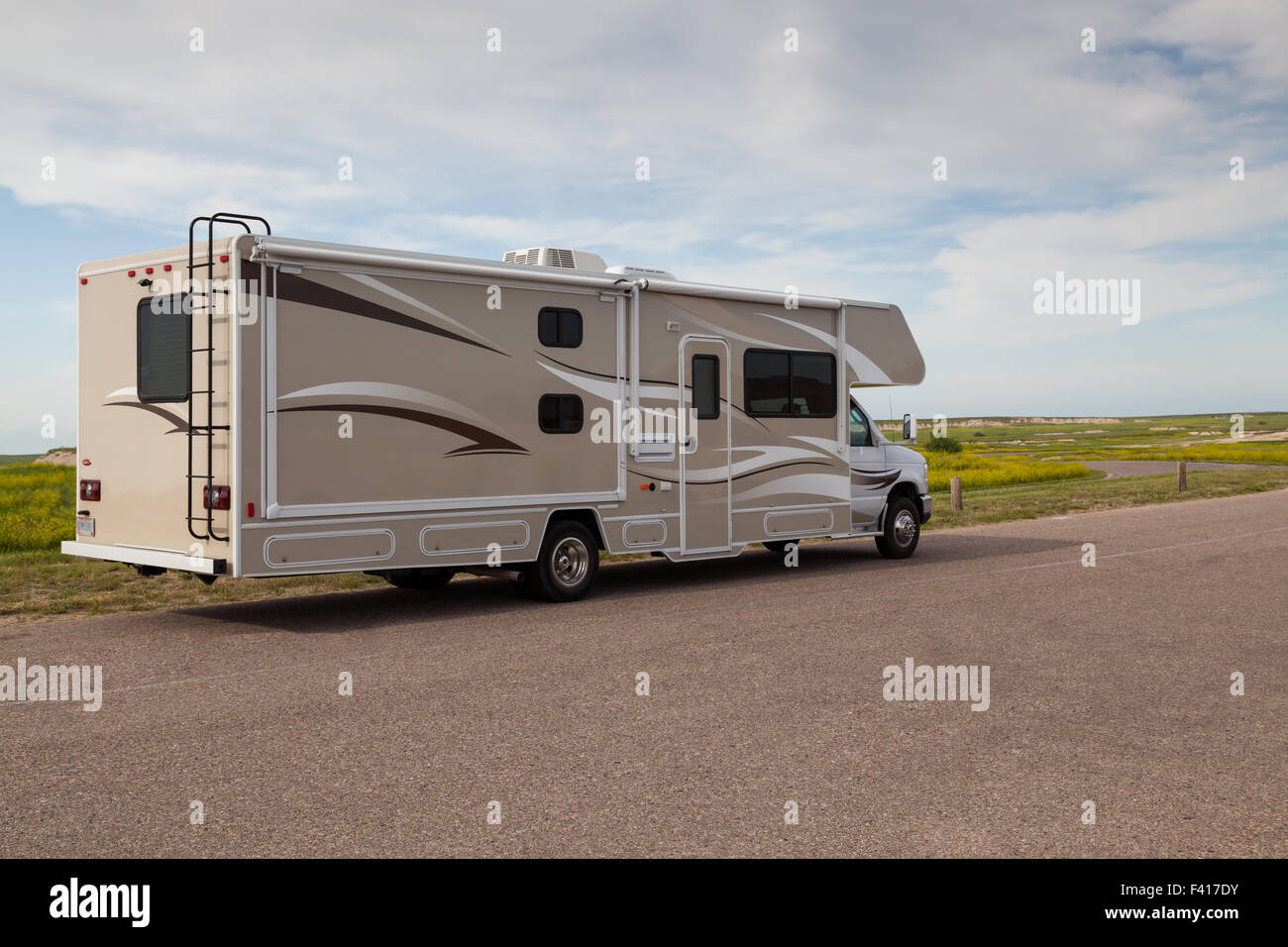 Braune und weiße Wohnmobil geparkt auf einem Plateau mit einem Wildblumen Feld dahinter in Badlands Nationalpark, South Dakota. Stockfoto