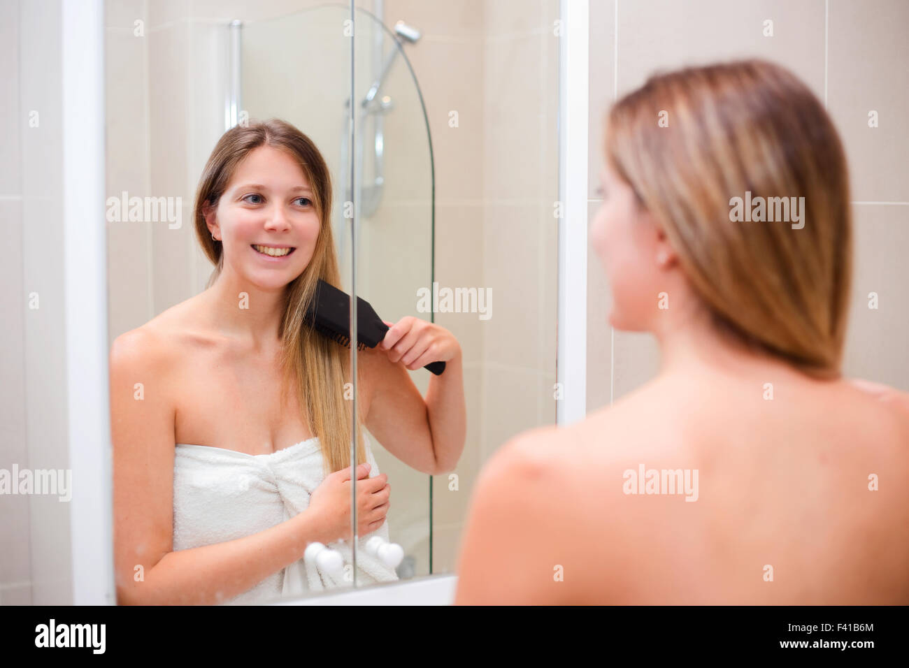junge Frau, Bürsten Sie ihr Haar im Bad Stockfoto
