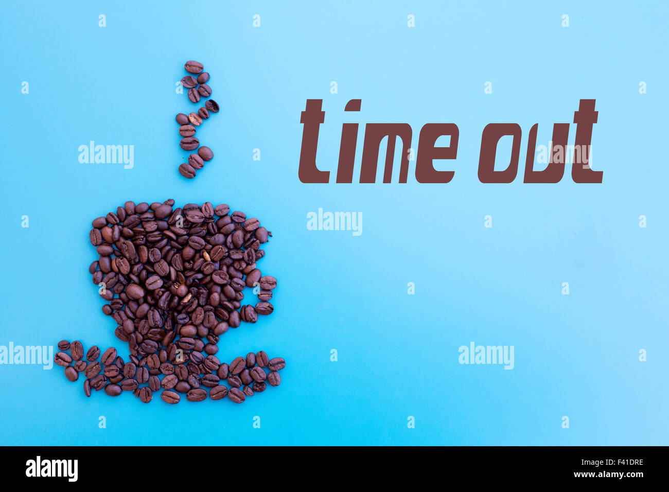 Kaffeebohnen in Form einer Tasse mit Wort 'Time Out' auf blauem Hintergrund Stockfoto