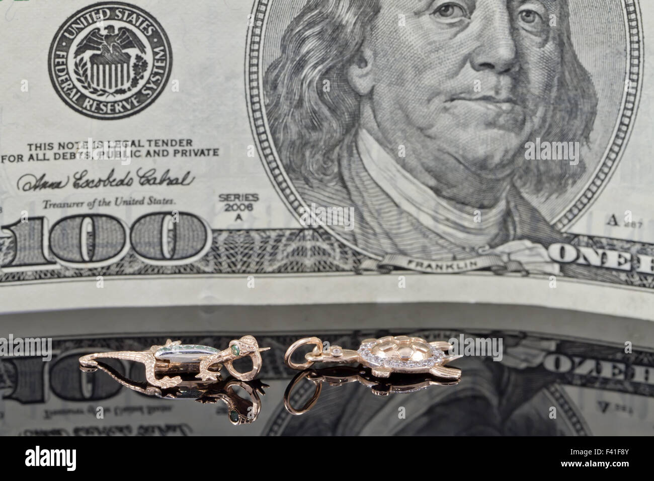 Gold Charms und hundert Dollar Rechnungen Stockfoto