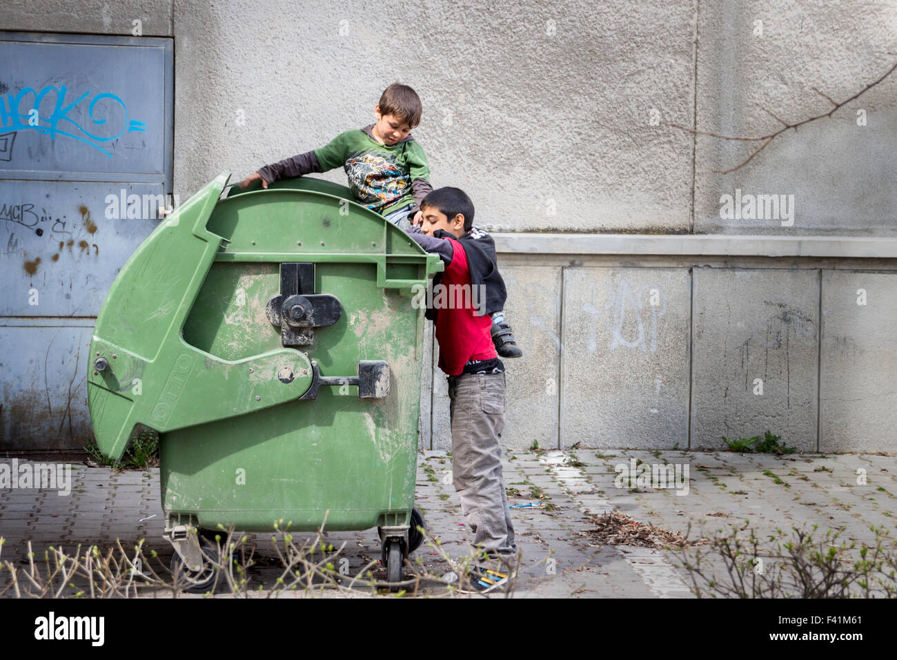 Zwei Zigeuner (Roma) jungen versucht, etwas zu essen oder etwas in nutzbare finden ein Müllcontainer Stockfoto