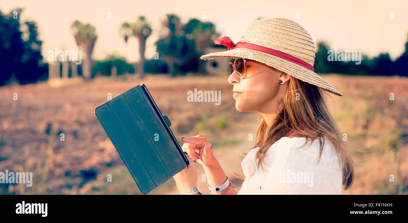 junge Frau im Lande arbeiten auf tablet Stockfoto