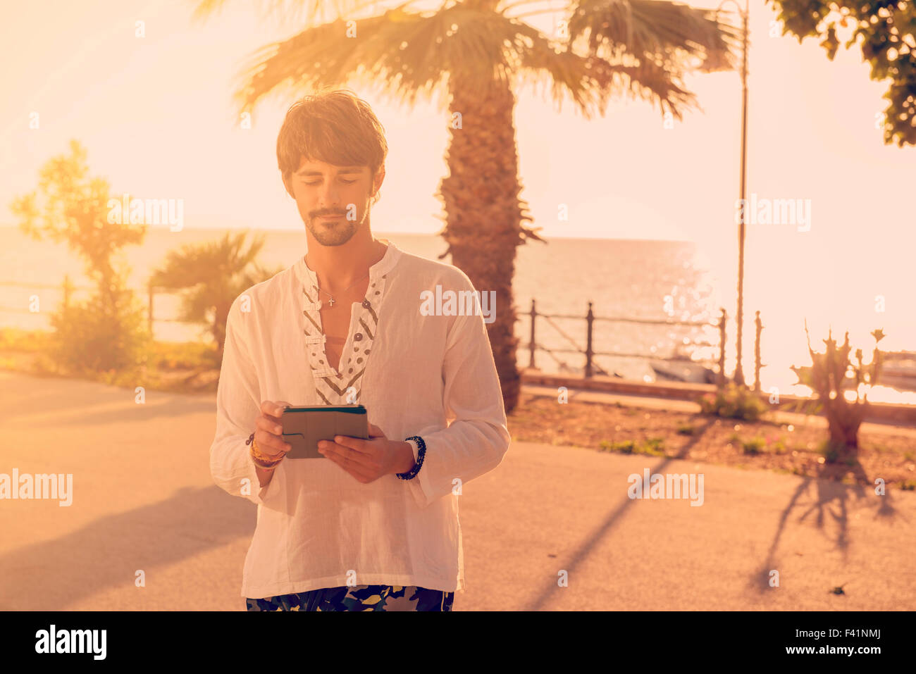 junger Mann mit digital-Tablette im Sommer am Meer Stockfoto