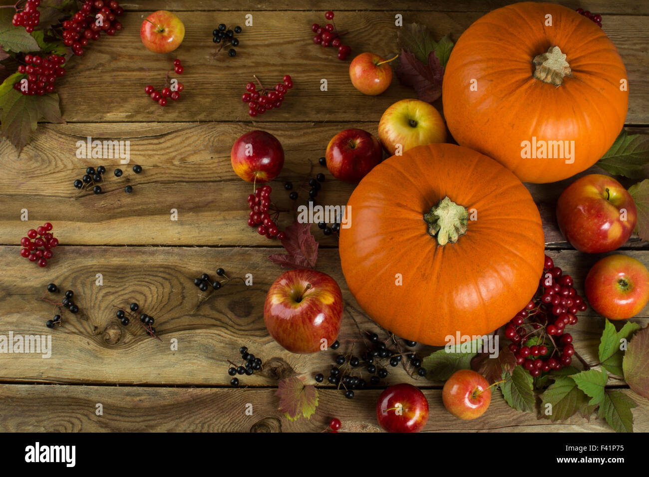 Reife Kürbisse, Äpfel, Beeren und Blätter auf hölzernen Hintergrund. Selektiven Fokus. Die Tönung Stockfoto