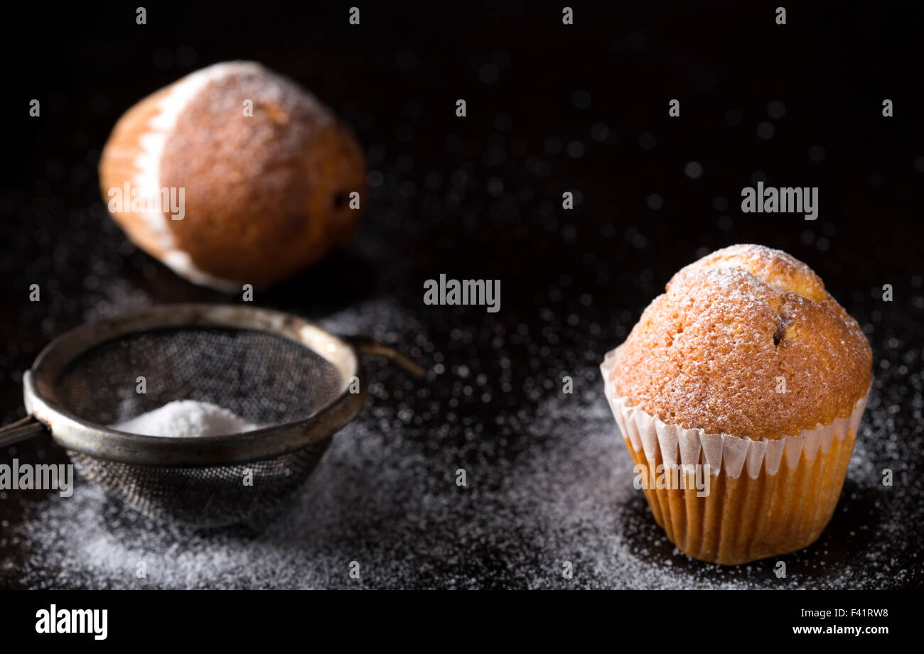 Schließen Sie Pf Zucker Puderzucker Madeleines und Sieb Stockfoto