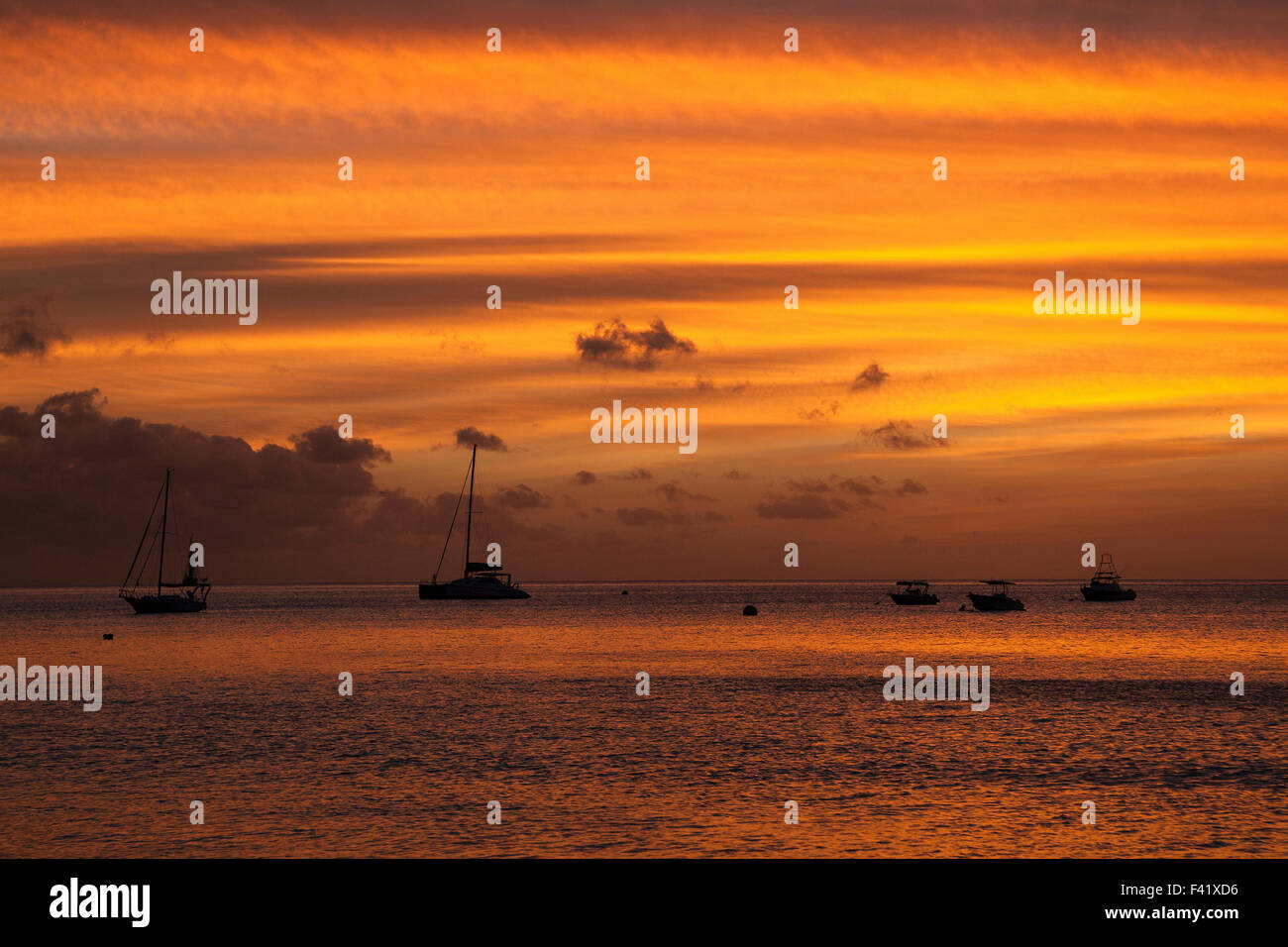 Sonnenuntergang mit Wolken, Boote vertäut im Meer, Beau Vallon Bay, Insel Mahe, Seychellen Stockfoto