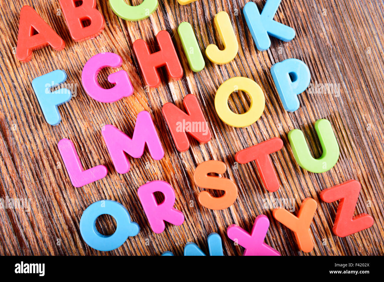 Zusammensetzung der bunten Kunststoff-Alphabet Buchstaben auf hölzernen Hintergrund Stockfoto