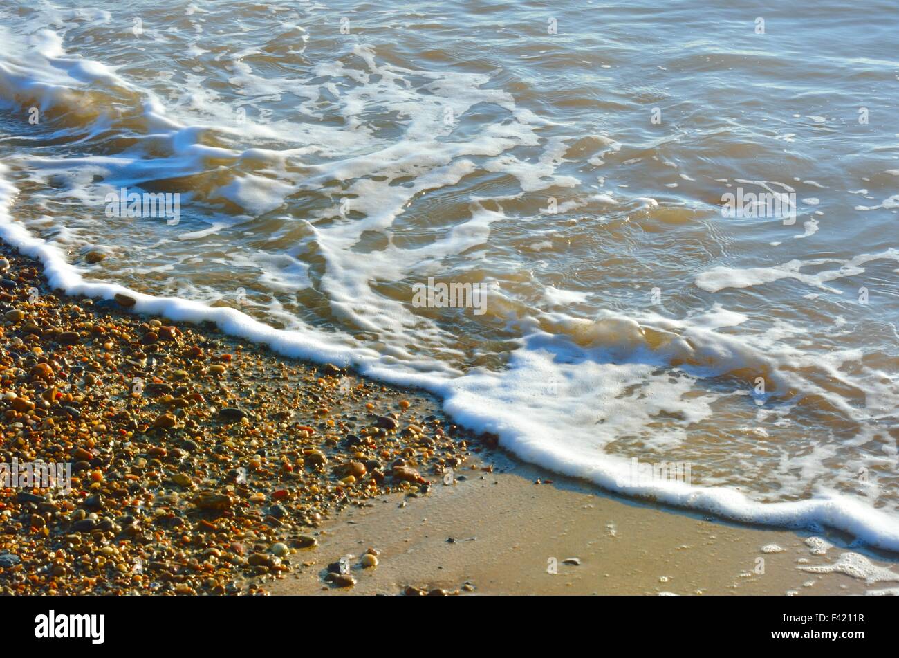 Wellen und Steinen am Ufer Stockfoto