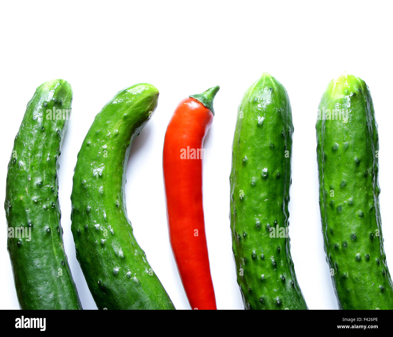 grüne Gurken mit red hot Chili peppers Stand heraus von der Masse ab Stockfoto