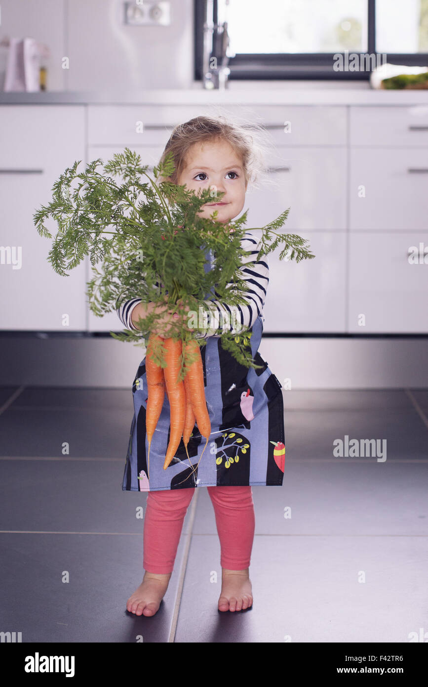 Kleine Mädchen halten frische Karotten Stockfoto