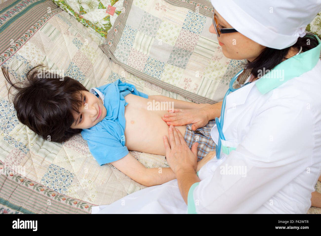 Arzt, Bauch eines jungen Patienten berühren Stockfoto