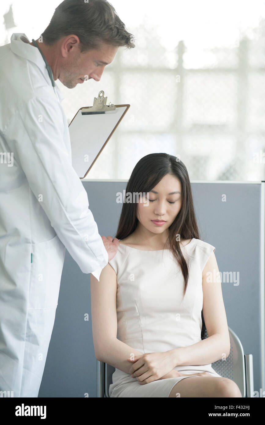 Arzt beruhigend Patienten im Wartezimmer Stockfoto