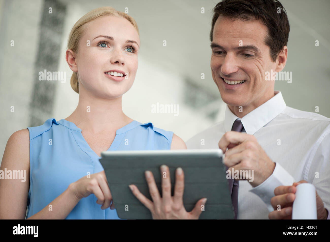 Business-Profis Blick auf digital-Tablette zusammen und lachen Stockfoto