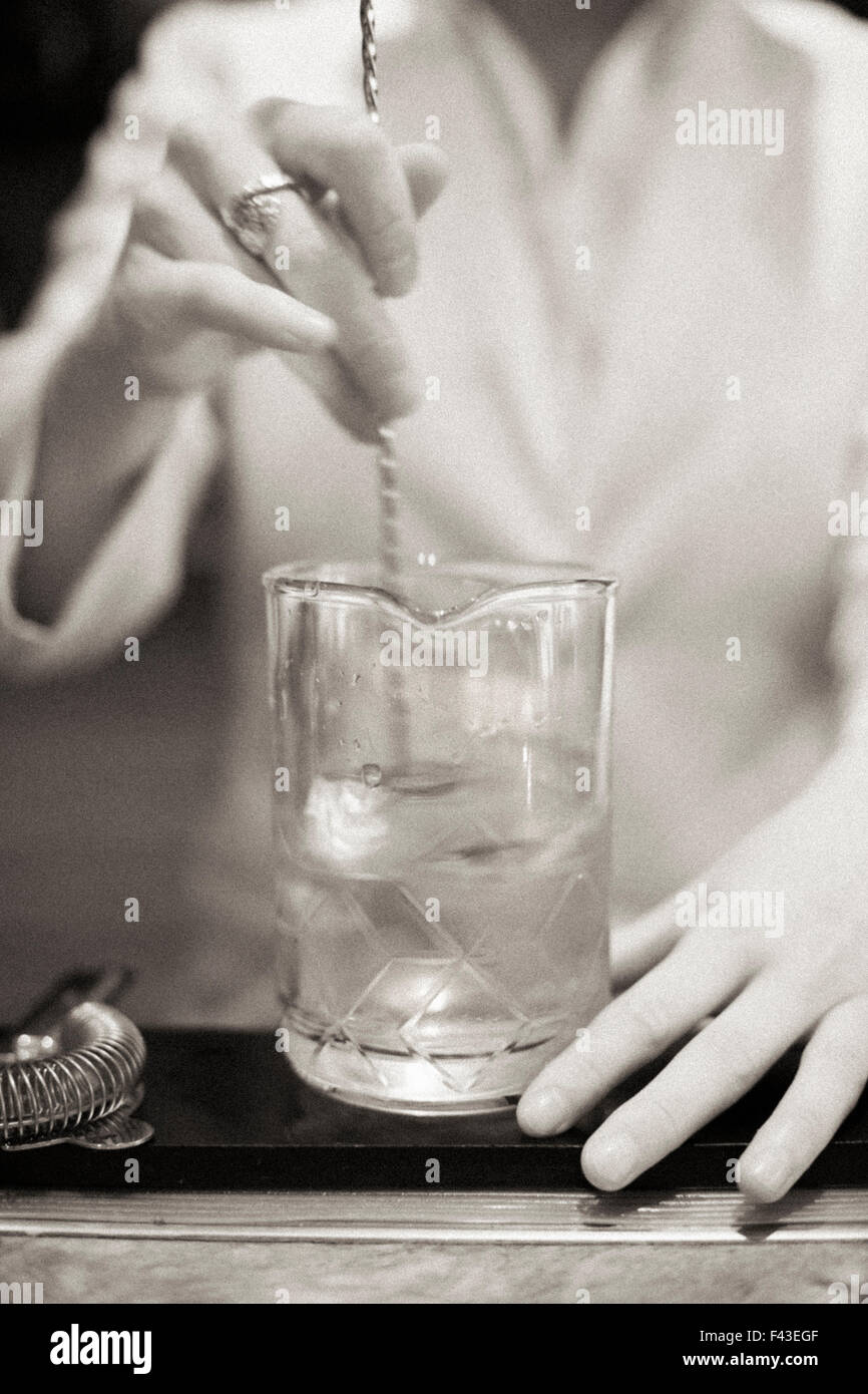 Eine junge Frau mischen einen Cocktail Mixer bei der Arbeit. Stockfoto