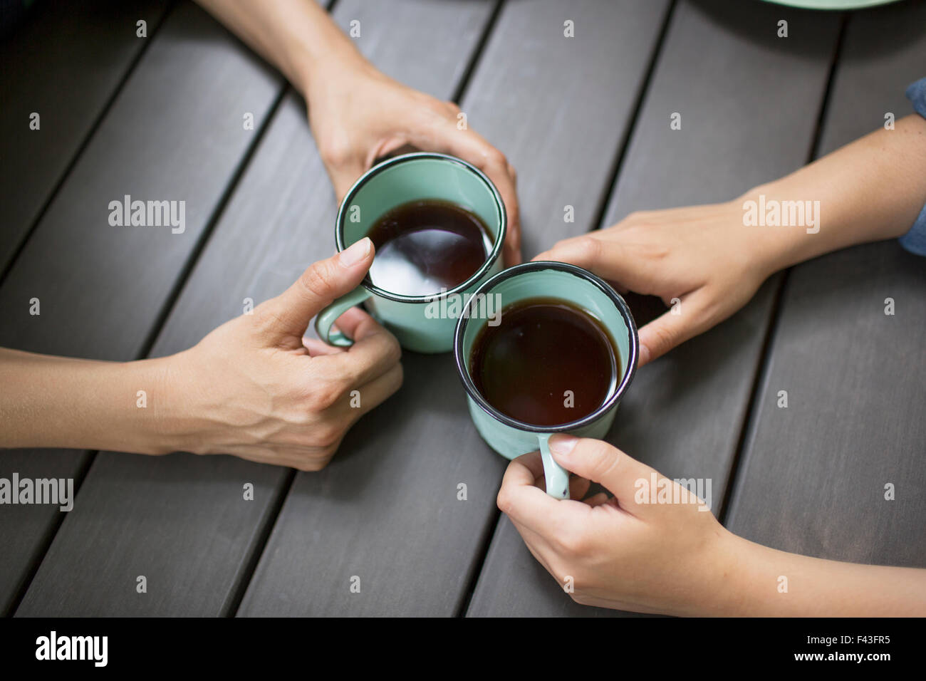 Zwei Personen an einem Tisch sitzen, Kaffee trinken, von oben gesehen. Stockfoto