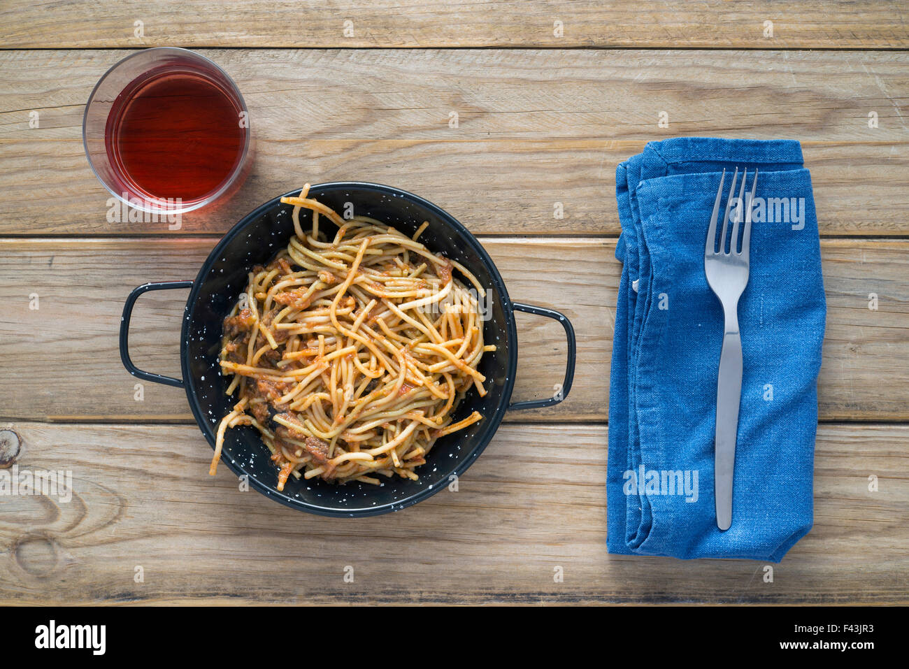Spaghetti mit Tomatensauce auf Holztisch. Nicht vergessen das Glas Rotwein Stockfoto