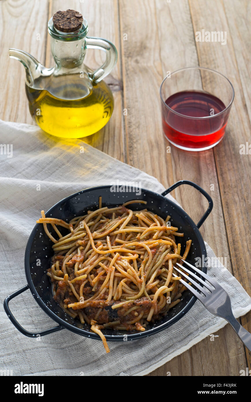 Spaghetti mit Tomatensauce auf Holztisch. Nicht vergessen das Glas Rotwein Stockfoto