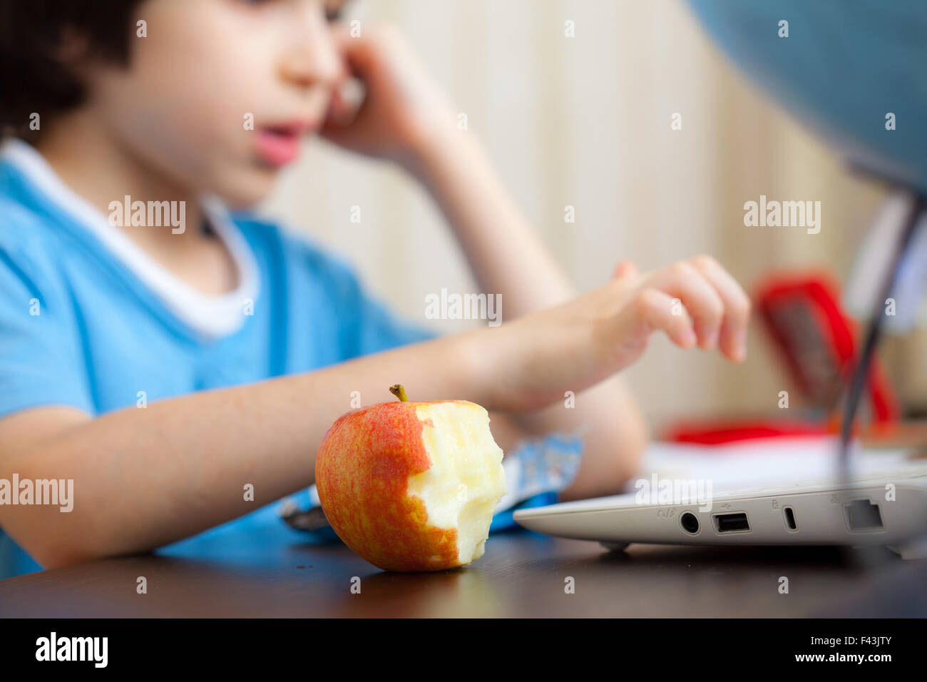 angebissene Apfel und ein Junge mit computer Stockfoto