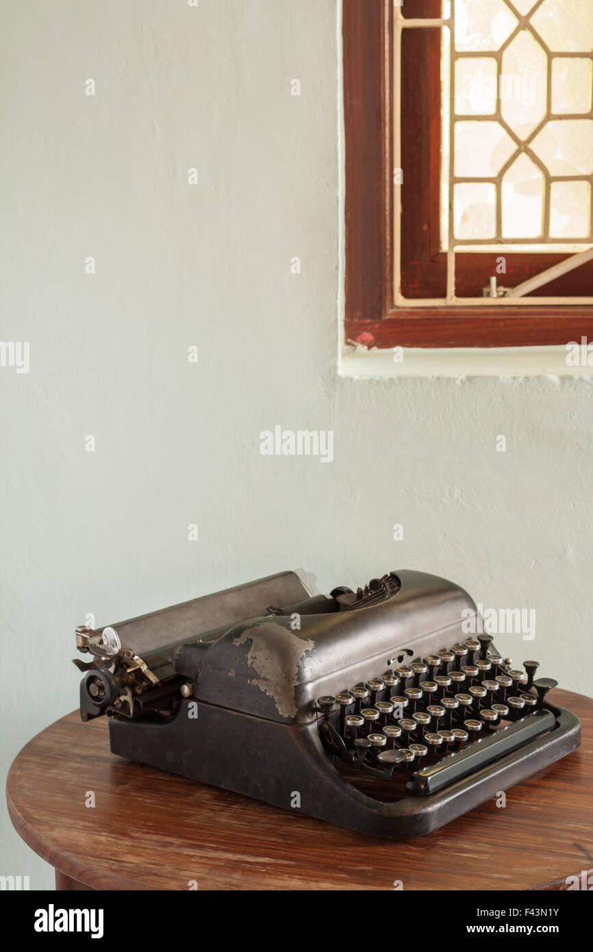 Vintage Schreibmaschine in technisch einwandfreiem Zustand sitzt auf einem alten Schreibtisch ungenutzt. Stockfoto