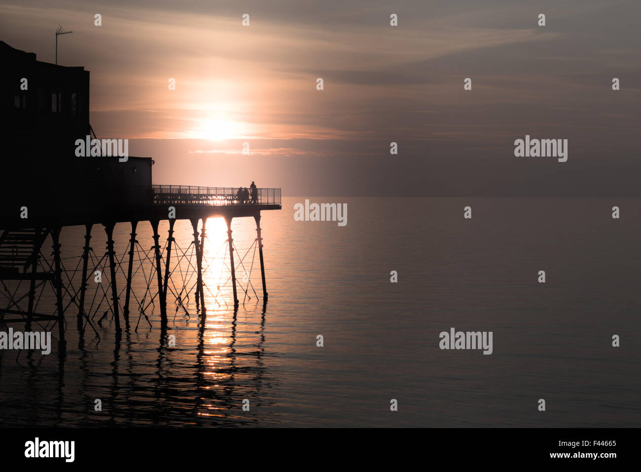 4 Personen auf Aberystwyth Pier bei Sonnenuntergang Stockfoto