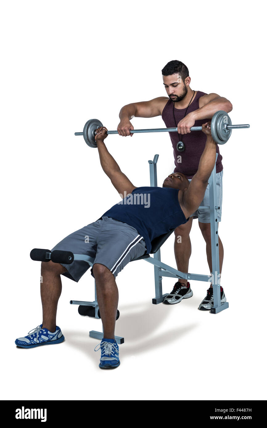 Trainer helfen muskulösen Mann, heben Sie die Hantel Stockfoto