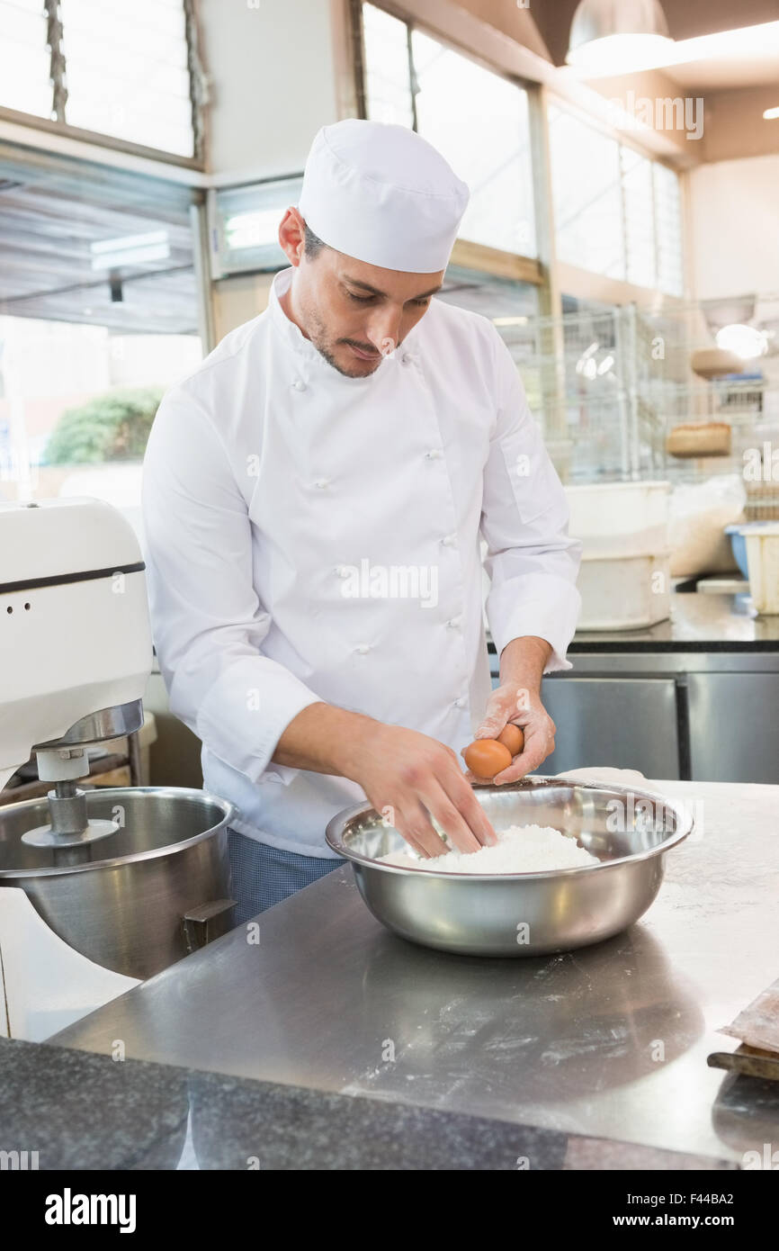 Baker knackenden Eiern auf Mehl Stockfoto