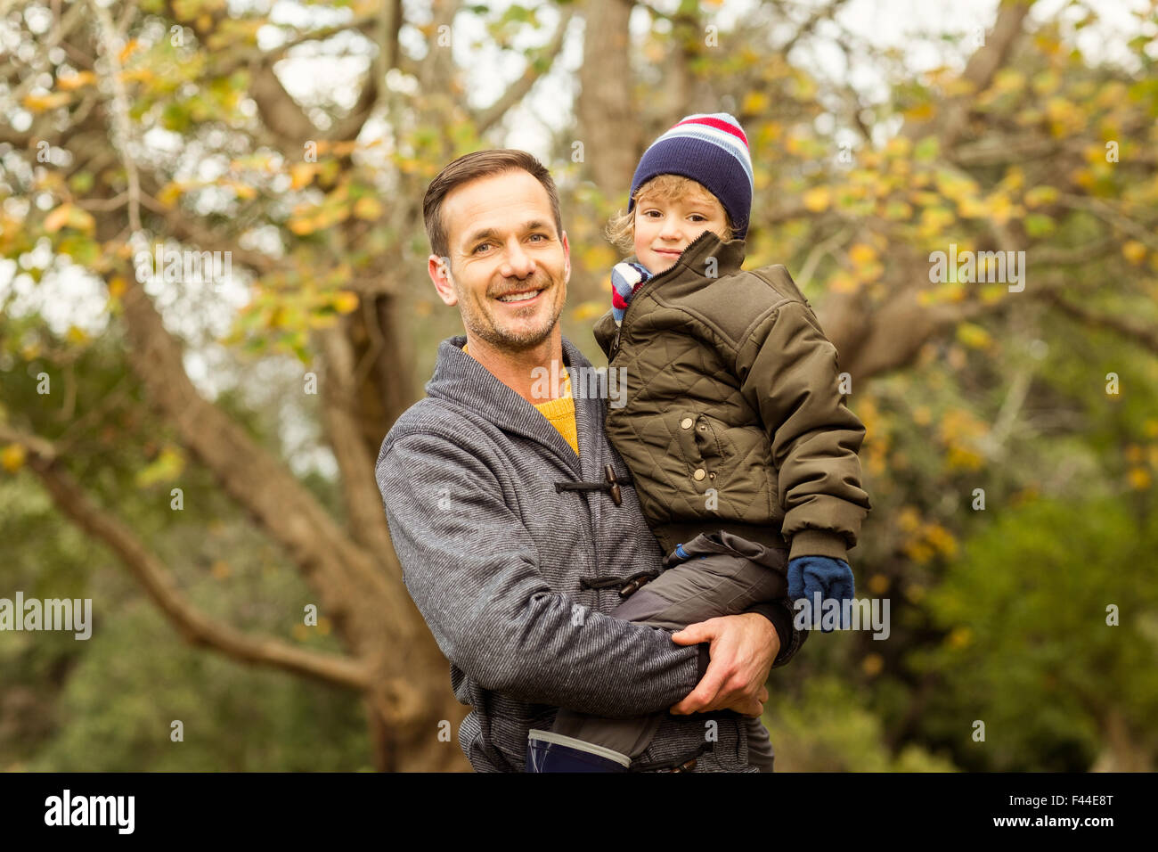 Junger Vater Aufhebung seines kleinen Sohnes im park Stockfoto