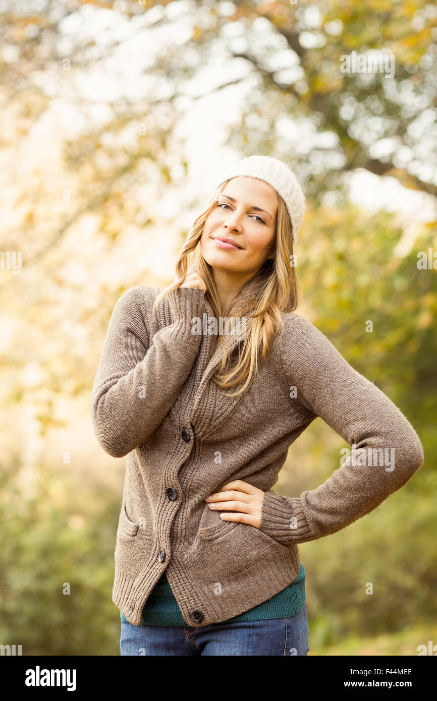 Hübsche Frau posiert mit Hand auf den Hüften lächelnd Stockfoto