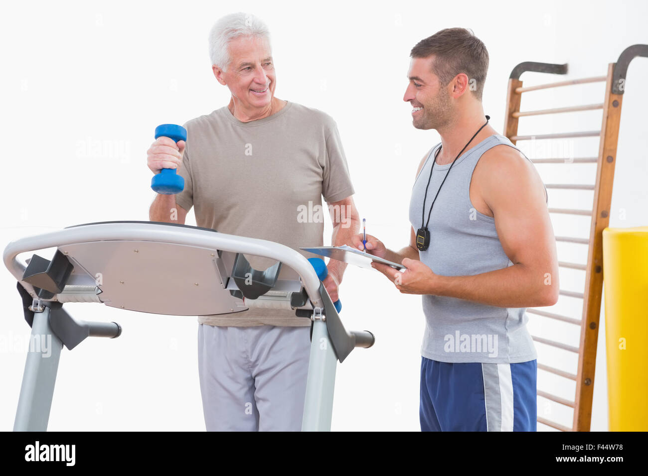 Senior woman auf Laufband mit trainer Stockfoto