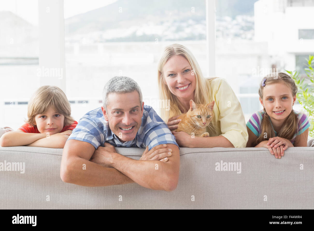 Glückliche Familie mit Katze zu Hause auf sofa Stockfoto