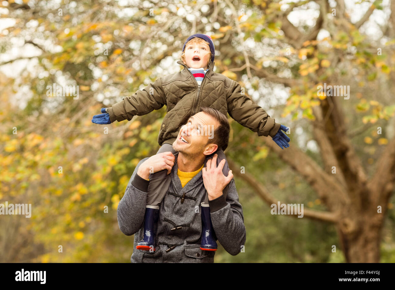 Junger Vater Aufhebung seines kleinen Sohnes im park Stockfoto