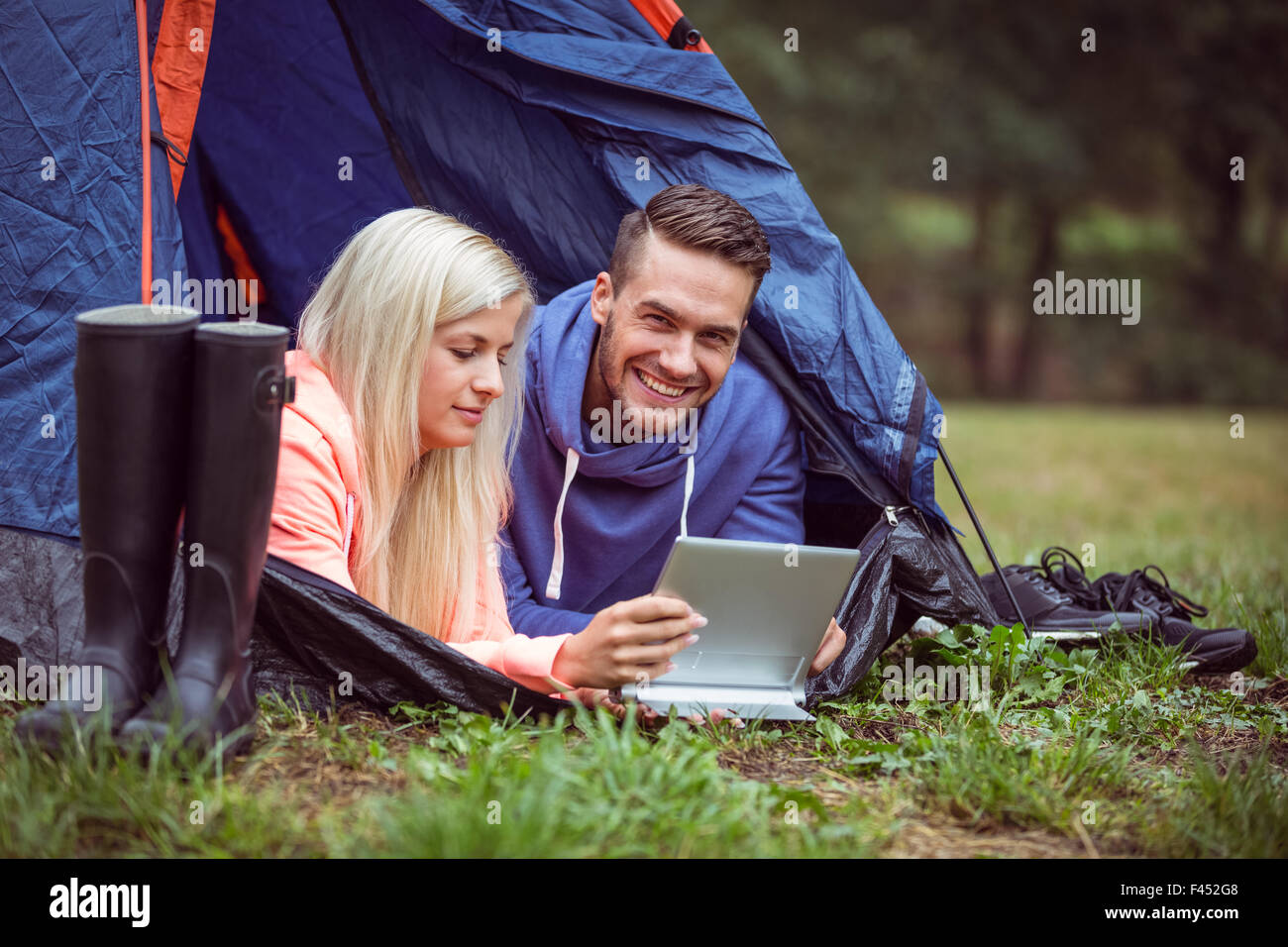 Glückliches Paar liegen in ihrem Zelt mit tablet Stockfoto