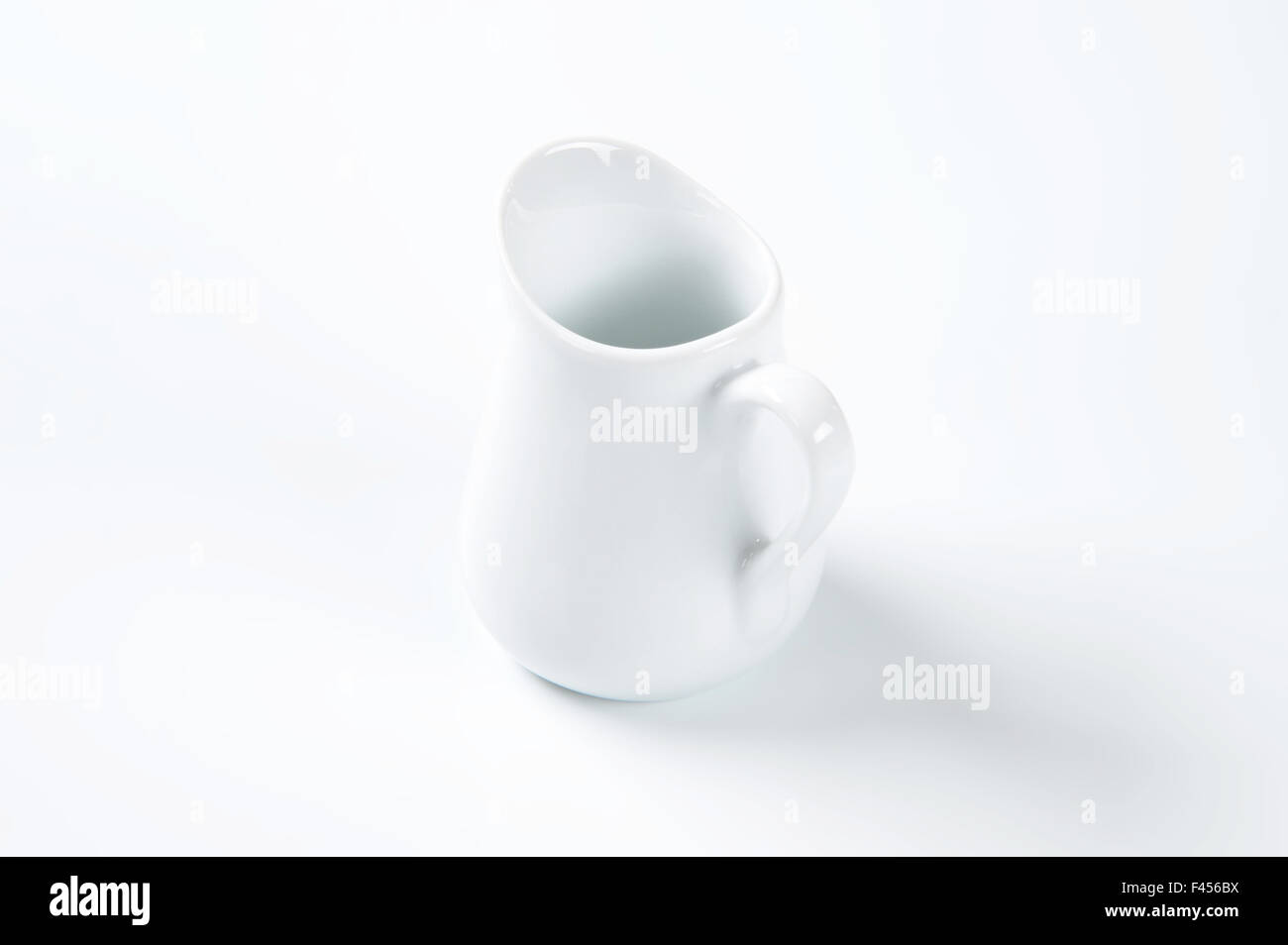 weiße Milchkännchen auf weißem Hintergrund Stockfoto